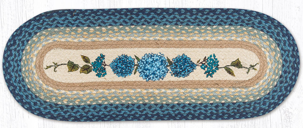 Oval-shaped braided rug with floral blue hydrangea design on a blue background